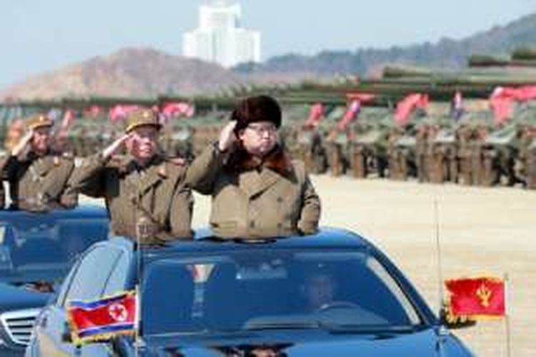 Pemimpin muda Korea Utara, Kim Jong Un, saat memeriksa latihan militer di sebuah tempat di negaranya, tanpa disebut namanya. Foto ini dirilis Kantor Berita Pusat Korea Utara (KCNA) pada 25 Maret 2016. 