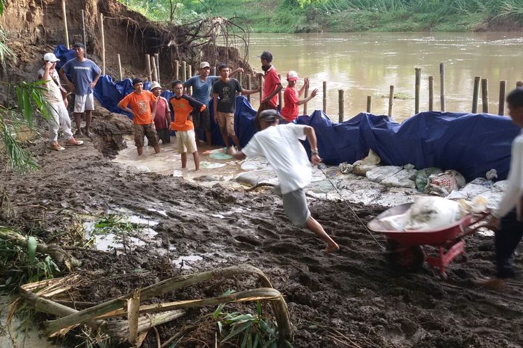 Ratusan pemuda dari Desa Bendungan, Kecamatan Wates, Kulon Progo, DI Yogyakarta, membangun kembali tanggul Sungai Serang yang jebol semalam hingga subuh, Minggu-Senin (17-18 Maret 2019). Usaha mereka dibantu eksavator untuk mempercepat pengerjaan tanggul darurat ini.