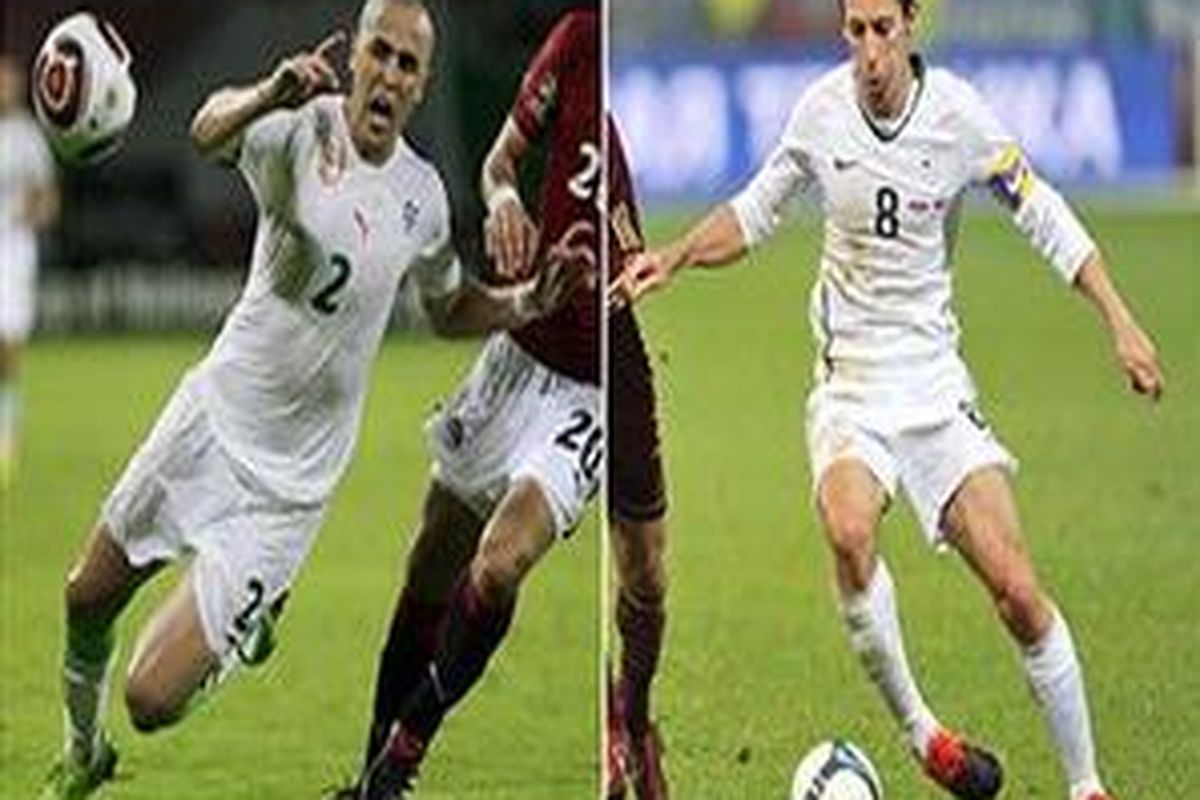 Pemain Aljazair, Madjid Bougherra (kiri) dan pemain Slovenia, Samir Handanovic (kanan).