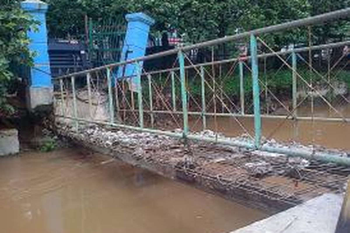 Jembatan yang menghubungkan Kelurahan Tengah dan Jalan Raya Bogor di atas Kali Baru, Kecamatan Kramat Jati, Jakarta Timur, ambles akibat turap di tepi sungai tersebut ambrol pada Selasa (21/1/2014) malam.