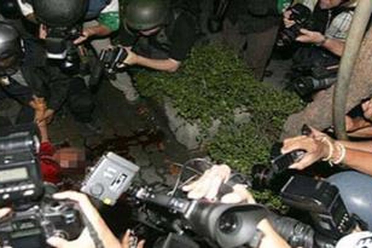 Fotografer mengerubungi seorang demonstran anti-pemerintah Thailand yang tewas tertembak. 