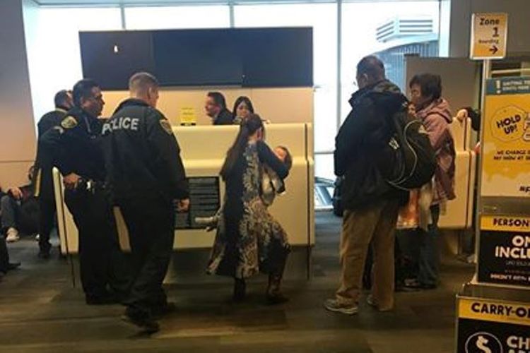 Seorang penumpang Spirit Airlines mengabadikan saat-saat polisi bandara di Houston, Texas menggiring Mei Rui dan bayinya dari dalam pesawat.
