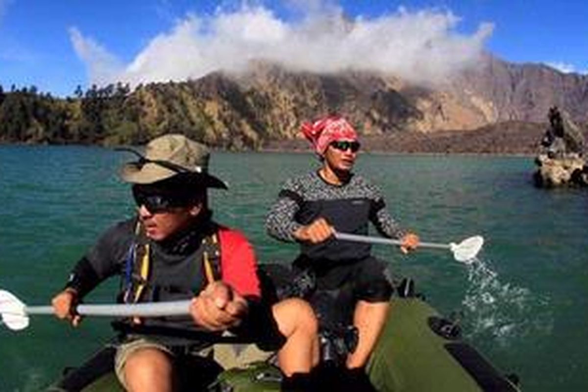 Tim Ekspedisi Cincin Api Kompas menggunakan perahu karet mengarungi Danau Segara Anak usai melakukan pendakian Gunung Barujari (kanan belakang) yang terletak di kaldera Gunung Rinjani (3.726 mdpl), Lombok, Nusa Tenggara Barat, Kamis (29/9/2011). Gunung Barujari (2.376 mdpl) merupakan gunung baru yang muncul di kaldera karena adanya aktivitas vulkanik dan disebut sebagai zona inti Gunung Rinjani. Gunung baru terakhir meletus 2009 dan menciptakan kawah baru di sisi timur. 