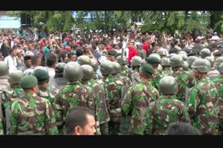 Massa berhadapan dengan pasukan TNI di depan markas Kodim 01/01 BS Banda Aceh, Kota Banda Aceh, Senin (16/12/2013).