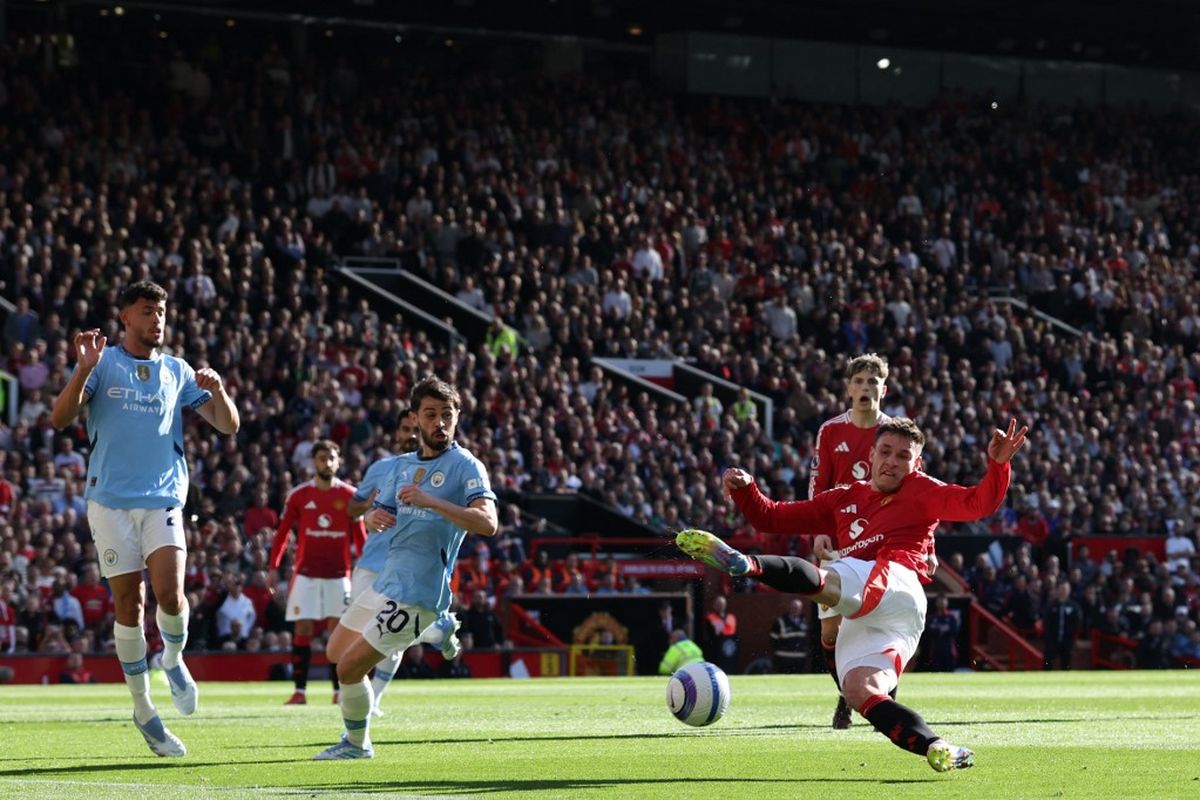 Manuel Ugarte (kanan) gagal menjangkau bola kala berlaga dalam pertandingan Liga Inggris antara Manchester United vs Manchester City di Old Trafford di Manchester, barat laut Inggris, pada 6 April 2025. (Photo by Darren Staples / AFP)