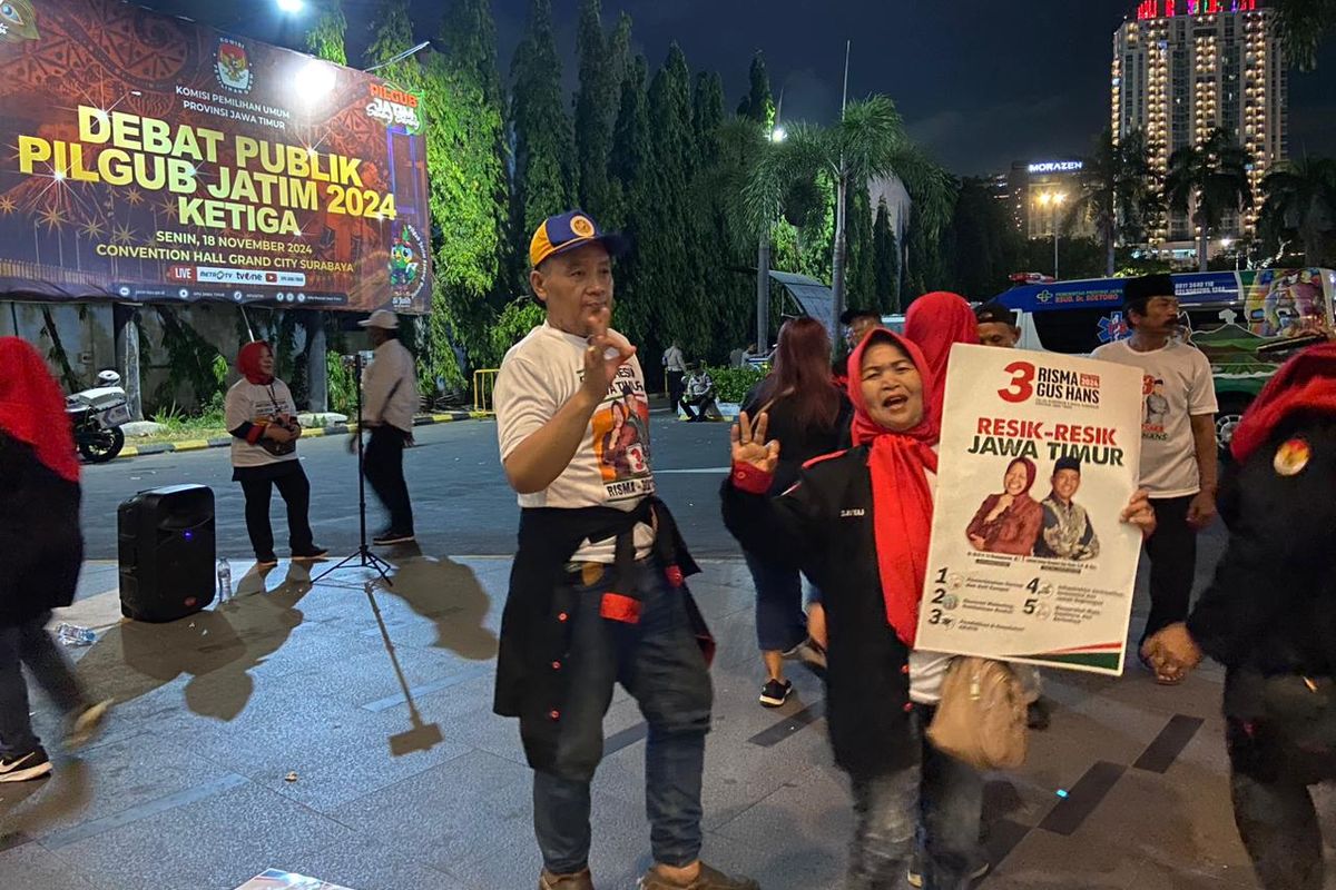 Pendukung Risma-Gus Hans yang berkaraoke membawa sound system pribadi di luar gedung saat debat Pilgub Jatim, Senin malam (18/11/2024).