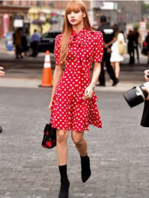 Lisa Blackpink mengenakan gaun polkadot merah dalam salah satu acara fashion yang dihadirinya