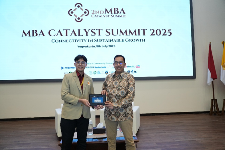 Wakil Direktur Utama Telkom Muhammad Awaluddin saat menerima cinderamata dari perwakilan mahasiswa UGM pada acara MBA Catalyst Summit 2025 di Universitas Gadjah Mada (UGM), Sabtu (5/7/2025). 