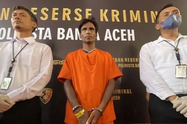 Tersangka Muhammed Amin (tengah) dikawal personel Satreskrim Polresta Banda Aceh saat rilis kasus penyelundupan Rohingya di Banda Aceh, Aceh, Senin (18/12/2023). 
