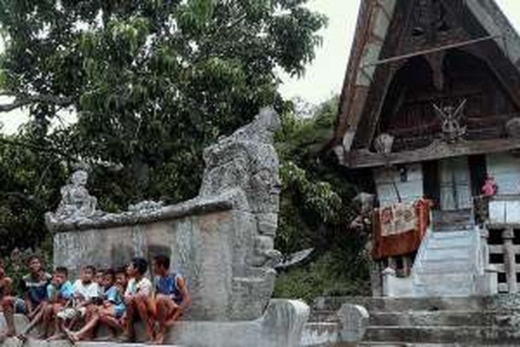 Anak-anak bermain di depan rumah warga di Simarmata, Sihotang, Sumatera Utara, Selasa (21/6/2016). Sisa-sisa tradisi megalitikum berupa kubur batu dan lumpang untuk menumbuk padi masih terlihat di lokasi itu.