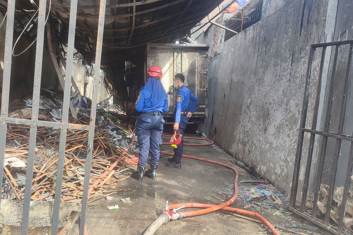 Petugas Pemadam Kebakaran Kota Bekasi melakukan pendinginan Gudang perabotan rumah tangga yang mengalami terbakar pada Rabu (3/7/24) 