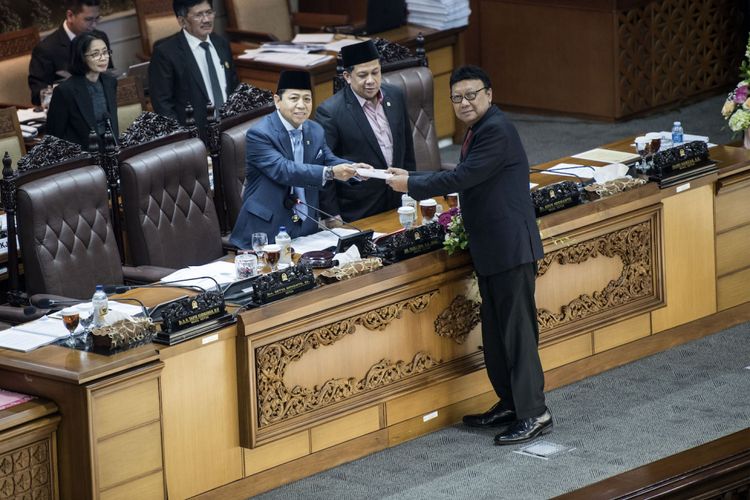 Menteri Dalam Negeri Tjahjo Kumolo (kanan) menyerahkan laporan pandangan pemerintah kepada Ketua DPR Setya Novanto (kiri) disaksikan Wakil Ketua DPR Fahri Hamzah (kedua kiri) saat rapat sidang Paripurna DPR ke-32 masa persidangan V tahun sidang 2016-2017 di Kompleks Parlemen Senayan, Jakarta, Jumat (21/7/2017) dini hari. DPR mengesahkan RUU Pemilu menjadi undang-undang setelah melalui mekanisme dan memilih opsi A, yaitu Presidential Threshold sebesar 20 persen kursi DPR atau 25 persen suara nasional. 