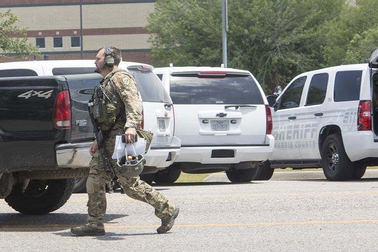 Seorang agen Biro Penyelidik Federal Amerika Serikat (FBI) berpakaian lengkap berada di tempat parkir SMA Santa Fe, Texas, pada Jumat (18/5/2018). Dalam penembakan tersebut, dilaporkan 10 orang tewas.