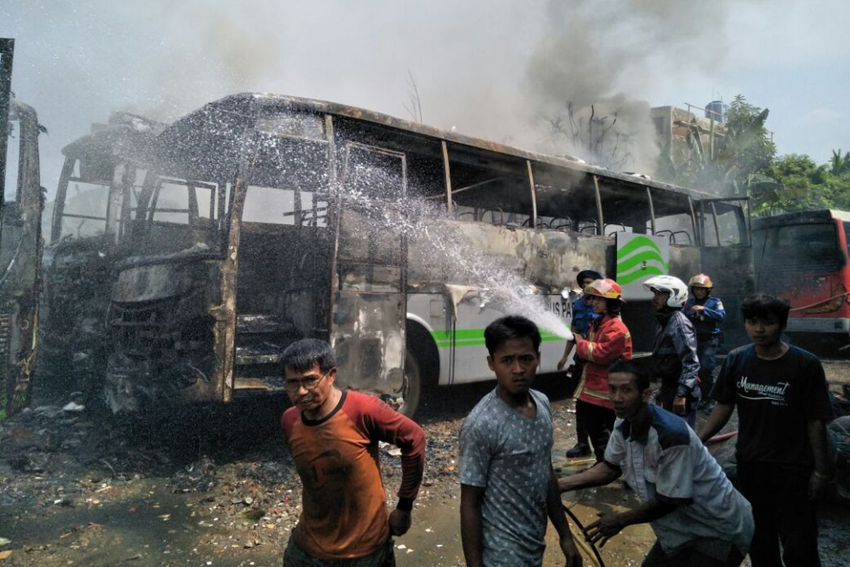 Warga bersama petugas pemadam berusaha memadamkan api di pool bus Jatiasih Bekasi Selasa (15/5/2018)