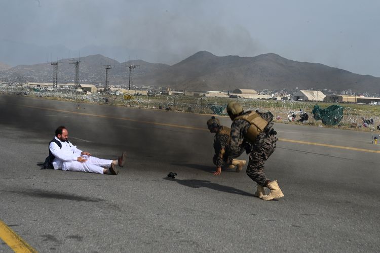 Dua anggota pasukan elite Taliban, Badrid 313, dan seorang jurnalis berdiri setelah mereka terjatuh dari pikap saat berselebrasi di Bandara Kabul, Afghanistan, pada 31 Agustus 2021.