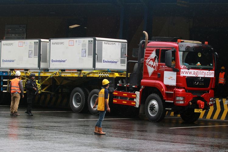 Pekerja dengan penjagaan petugas kepolisian melakukan bongkar muat Envirotainer berisi vaksin COVID-19 Sinovac setibanya dari Beijing di Terminal Cargo Bandara Soekarno Hatta, Tangerang, Banten, Kamis (31/12/2020). Sebanyak 1,8 juta dosis vaksin COVID-19 Sinovac kembali tiba di Indonesia yang selanjutnya dibawa ke Bio Farma Bandung untuk dilakukan uji klinis. ANTARA FOTO/Muhammad Iqbal/aww.
