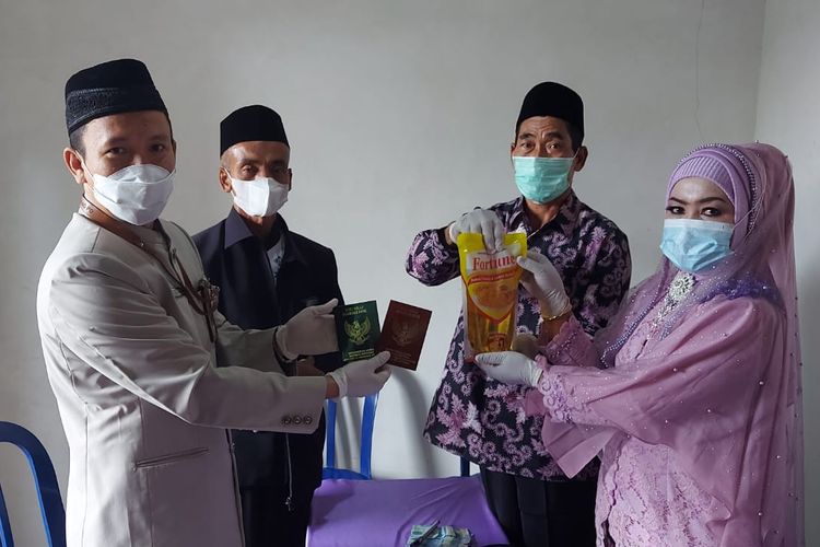 MAHAR—Pengantin pria bernama Supadi mengangkat minyak goreng kemasan berisi satu liter sebagai mahar perkawinannya menikah dengan Sumariati di Desa Suru, Kecamatan Sooko, Kabupaten Ponorogo, Jawa Timur, Selasa (22/2/2022).