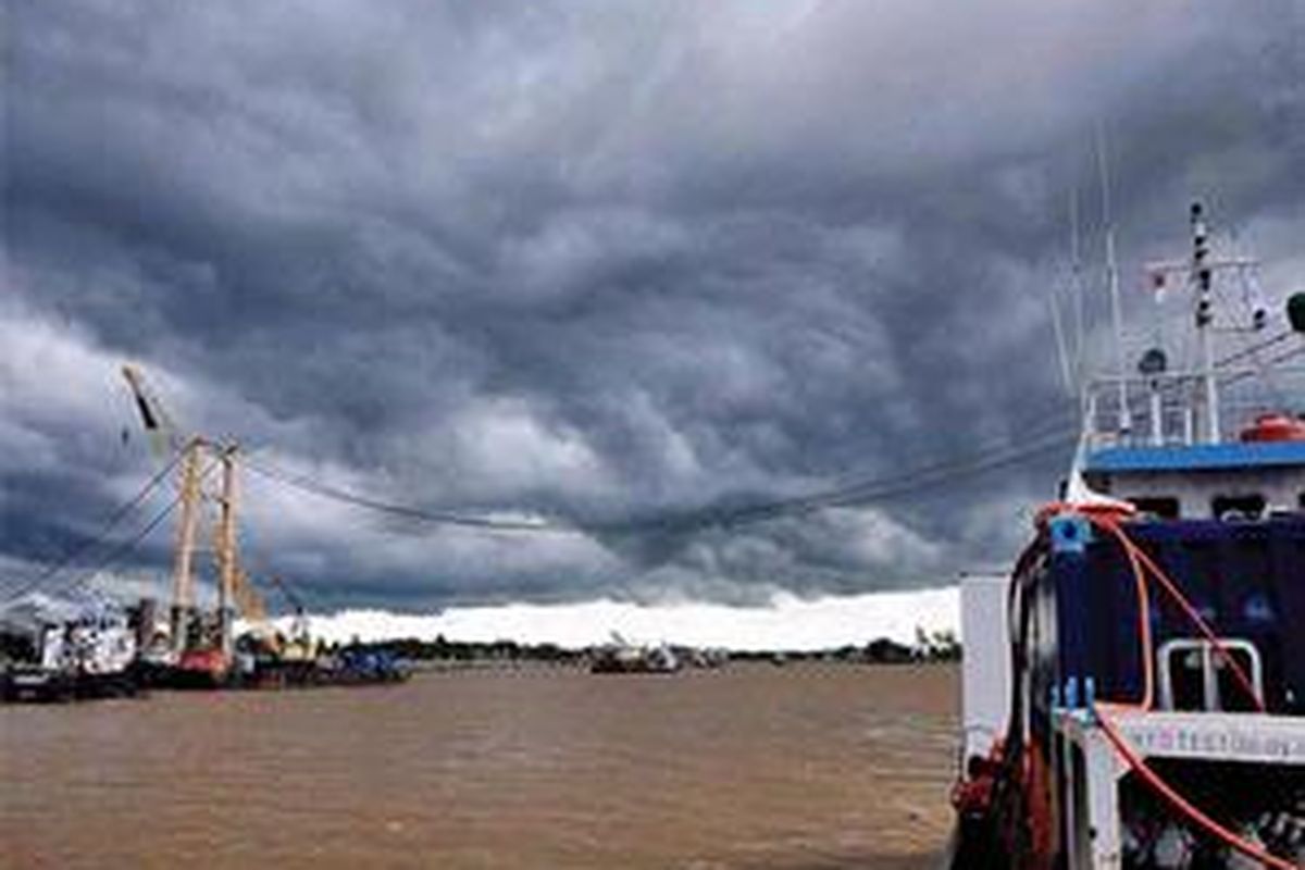Awan gelap menyelimuti proses evakuasi kendaraan yang terjatuh di dasar Sungai Mahakam di Tenggarong, Kabupaten Kutai Kartanegara, Kalimantan Timur, Senin (5/12). Proses evakuasi kendaraan yang tenggelam akibat ambruknya Jembatan Kartanegara ini dihentikan karena cuaca buruk dan kuatnya arus bawah Sungai Mahakam yang mencapai 1,6 knot.