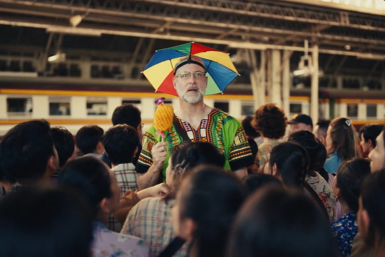 Seorang karyawan digambarkan tengah kebingungan di stasiun kereta di iklan Apple The Underdogs: OOO.