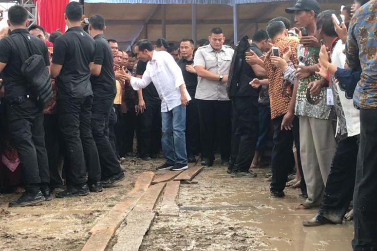 Presiden Joko Widodo saat melintasi genangan air di acara temu petani Lampung di Desa Playangan, Kecamatan Pardasuka, Kabupaten Pringsewu, Lampung, Sabtu (24/11/2018).