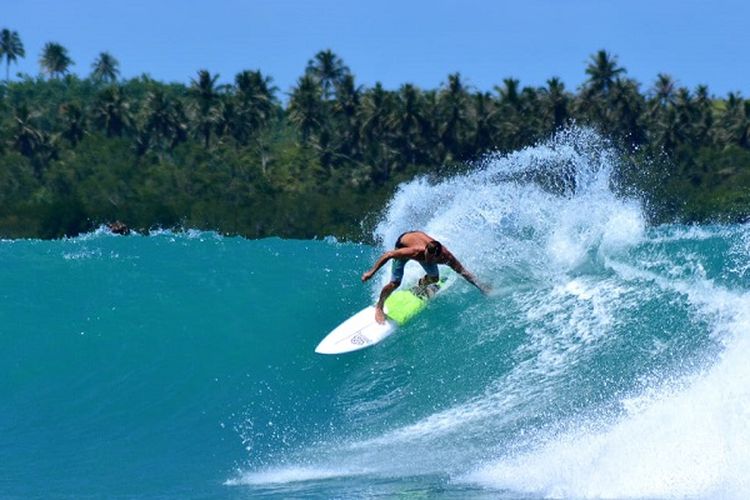 Peselancar tengah beraksi di pantai Sorake 