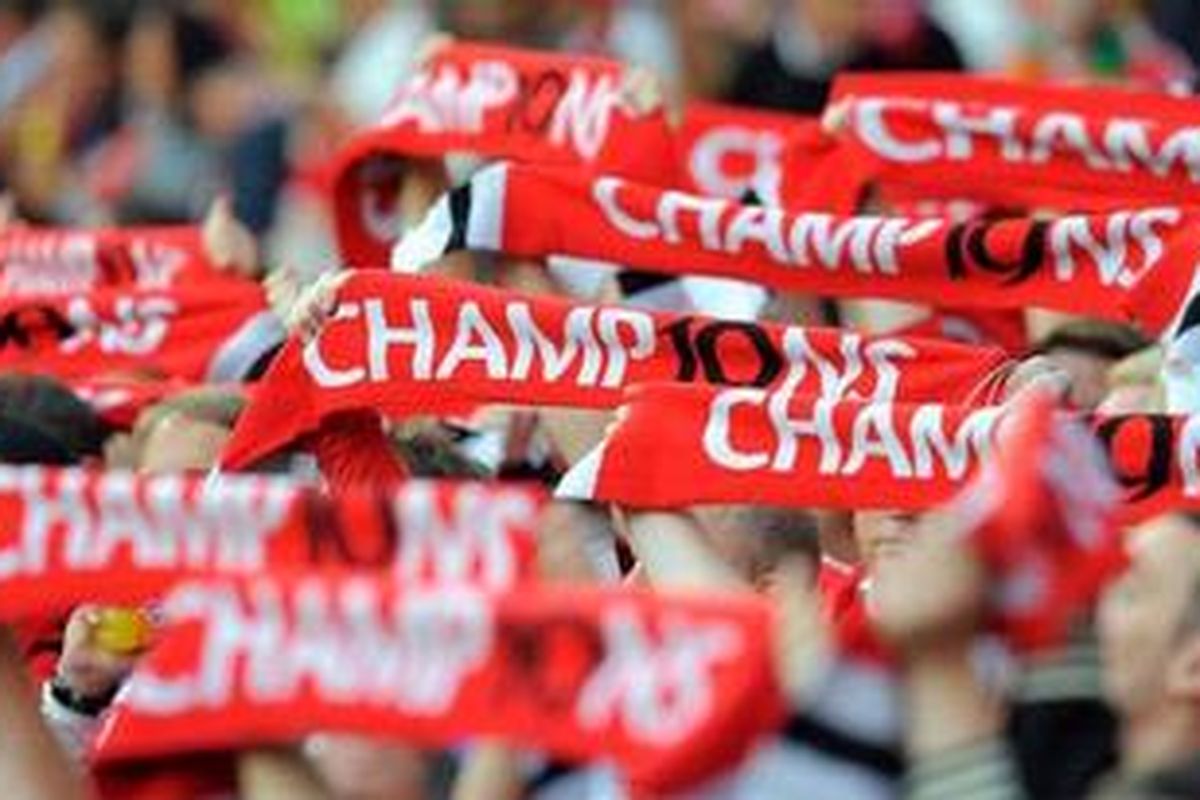 Pendukung Manchester United membengtankan syal sebelum pertandingan Liga Inggris antara Manchester United dan Tottenham Hotspur di Stadion Old Trafford di Kota Manchester, Inggris, 22 Agustus 2011.