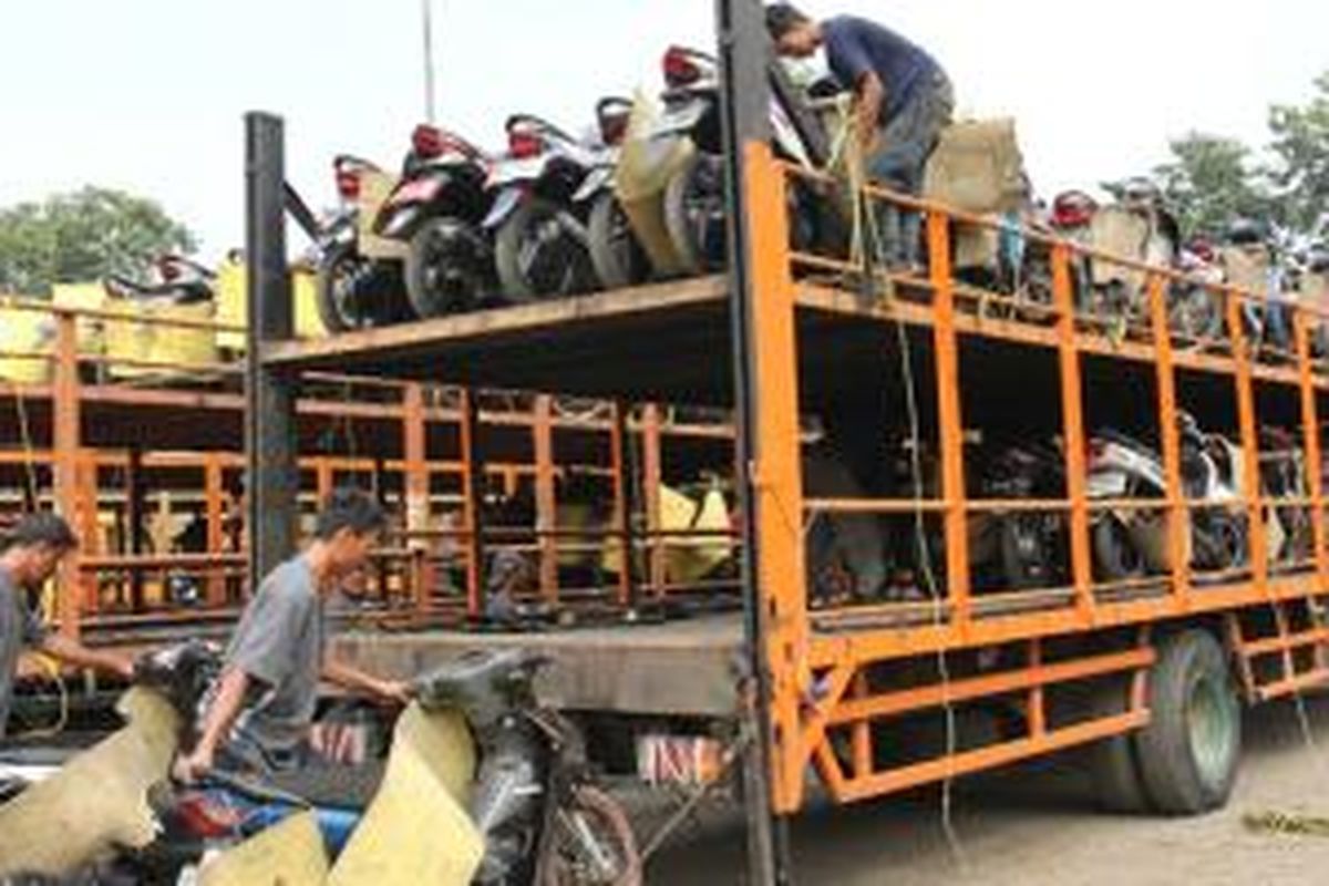 Para pekerja mempersiapkan sepeda motor pemudik peserta MBBH untuk diberangkatkan dengan aman ke kota tujuan di Pulomas, Jakarta Timur (11/7). Sebanyak 1.062 sepeda motor pemudik diberangkatkan ke kota Yogyakarta dan Semarang menggunakan 22 truk pengangkut sepeda motor.