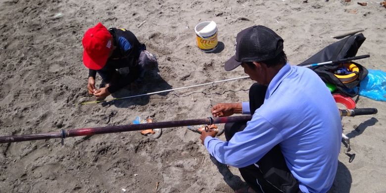 Warga sedang memancing di pinggiran pantai Desa Hagu Barat Laut, Kecamatan Banda Sakti, Lhokseumawe, Aceh, Minggu (23/7/2017).