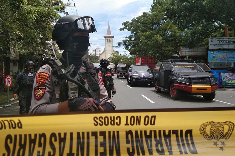 Petugas kepolisian berjaga di lokasi dugaan bom bunuh diri di depan Gereja Katedral Makassar, Sulawesi Selatan, Minggu (28/3/2021). ANTARA FOTO/Arnas Padda/wpa/foc.