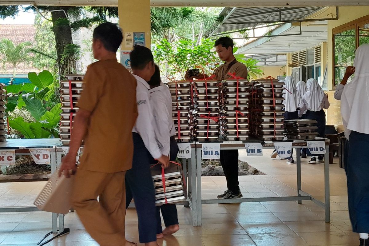 Pelajar mengembalikan ompreng MBG me meja display di SMP Negeri 3 Wates, Kabupaten Kulon Progo, Daerah Istimewa Yogyakarta.