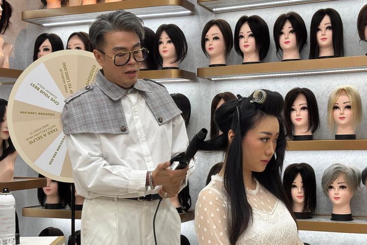 Hair stylist Indra Tanudarma mendemokan cara menata rambut yang menggunakan wig di acara pembukaan cabang kedua Beauty Crown di Kelapa Gading, Jakarta Utara (22/10/2025).