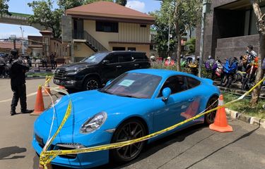 Mobil jenis Porsche 911 Carrera S berwarna biru milik tersangka Doni Salmanan yang disita polisi bakal menjadi barang bukti terkait kasus penipuan dan pencucian uang investasi ilegan binary option sang selebgram sudah digaris polisi di Bareskrim Polri, Senin (14/3/2022).