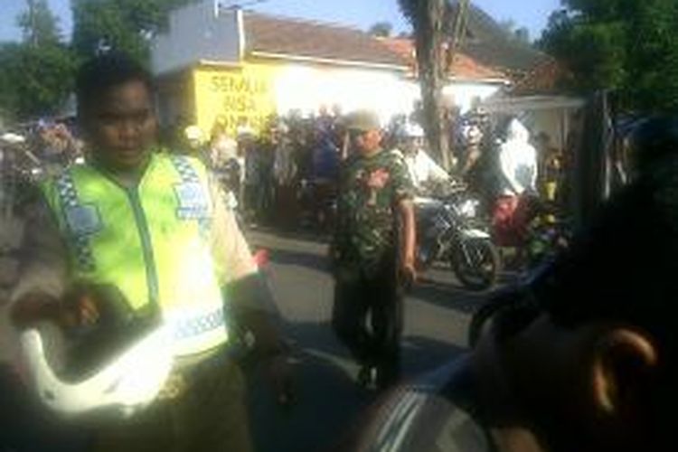 Anggota Sat Lantas Polres Bangkalan saat mengurai kemacetan setelah kejadian tabrakan maut yang disebabkan truk bermuatan pasir menabrak warung takjil, Ahad (21/7/2013). 