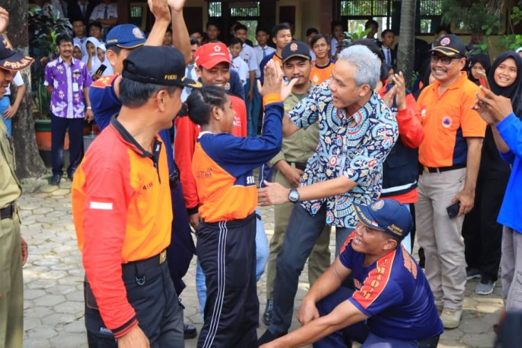 Gubernur Jawa Tengah (Jateng) Ganjar Pranowo mengajari Novensia Anouw, siswa kelas X SMAN 2 Demak ini untuk memadamkan api, Rabu (27/2/2019).