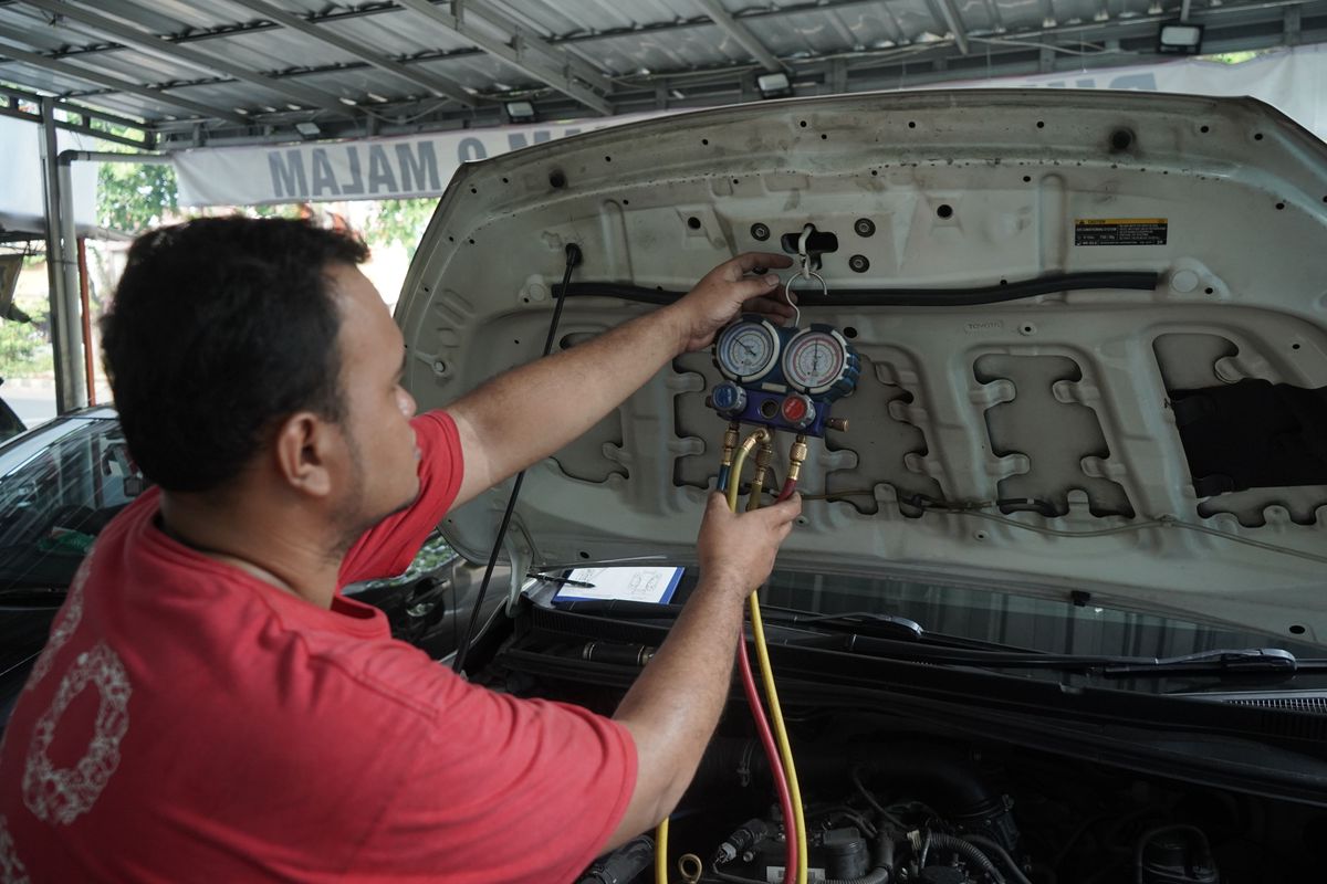 Salah satu pekerja sedang memperbaiki mobil di Dokter Mobil. 