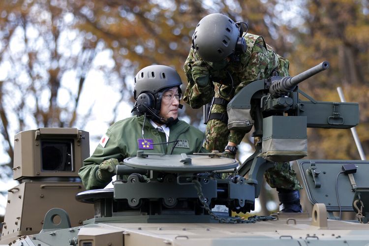 Perdana Menteri Jepang Fumio Kishida, kiri, mengendarai tank Tipe 10 Pasukan Bela Diri Darat Jepang (JGSDF) selama peninjauan di JGSDF Camp Asaka di Tokyo, Jepang, Sabtu, 27 November 2021.