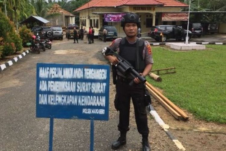 Polisi berjaga di depan Mapolsek Maro Sebo, Kabupaten Muarojambi, Jambi, setelah penyerangan dari seorang pria yang mengakibatkan dua orang polisi terluka, Selasa (22/5/2018). 