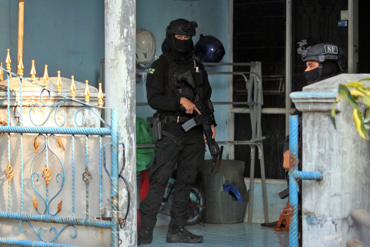 Anggota Densus 88 Mabes Polri berjaga saat melakukan penggeledahan rumah terduga anggota jaringan teroris Jemaah Ansharut Daulah (JAD), di Perumahan Taman Tridaya Indah, Tambun Selatan, Kabupaten Bekasi, Jawa Barat, Minggu (13/5). Tim Densus 88 melakukan penggeledahan serta menyita barang bukti dari rumah tersebut usai menangkap terduga teroris berinisial MI alias AB, di kawasan Cikarang Selatan karena diduga terlibat jaringan teroris JAD Jabodetabek. ANTARA FOTO/Risky Andrianto/ama/18