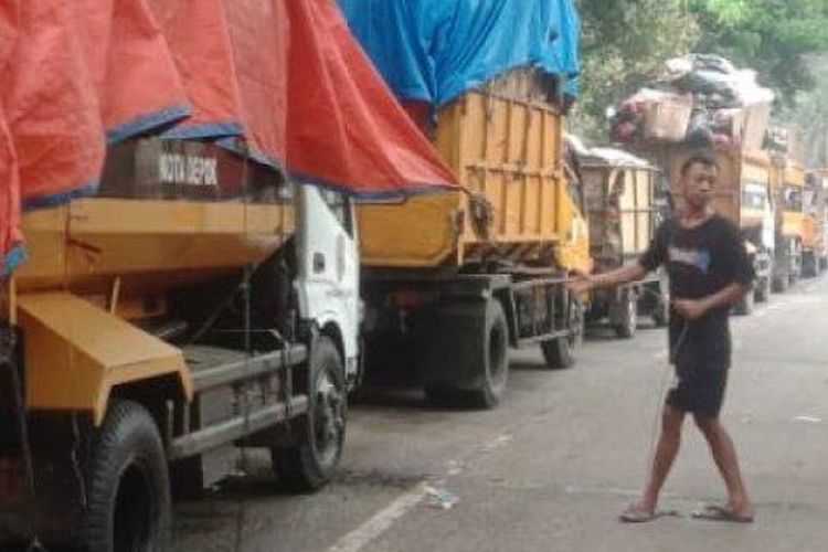 Sejumlah truk pengangkut sampah mengantre setelah akses jalan menuju Tempat Pembuangan Akhir (TPA) Cipayung Kota Depok, tertutup longsoran dari gunungan sampah.