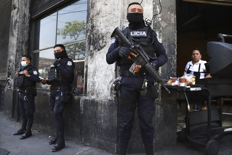 Polisi bersenjata lengkap menjaga jalan-jalan di pusat kota San Salvador, El Salvador, Minggu, 27 Maret 2022. 