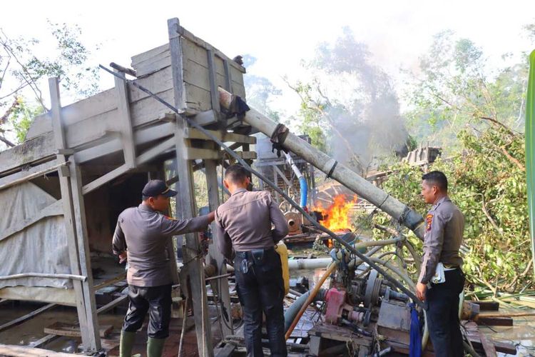 Petugas kepolisian membakar rakit tambang emas ilegal di Kecamatan Peranap, Kabupaten Indragiri Hulu, Riau, Rabu (22/2/2023).