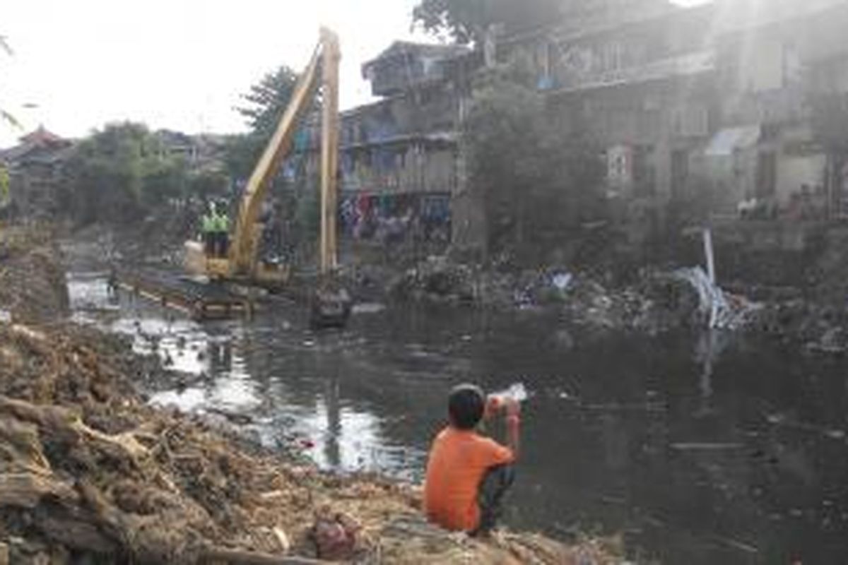 Warga Bukit Duri, Tebet, Jakarta Selatan menyaksikan penertiban sisa puing bongkaran di Kampung Pulo, Jatinegara, Jakarta Timur, Minggu (23/8/2015).