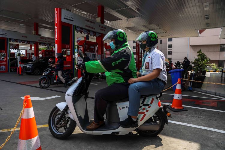 Pengemudi ojek daring mengganti baterai sepeda motor listrik dengan yang sudah penuh terisi di Stasiun Penukaran Baterai Kendaraan Listrik Umum (SPBKLU) di SPBU Pertamina, Jalan MT Haryono, Jakarta, Senin (28/3/2022). Pemerintah Indonesia menargetkan dua juta kendaraan listrik dapat digunakan oleh masyarakat Indonesia pada 2025 sebagai salah satu upaya untuk menerapkan penggunaan energi terbarukan.