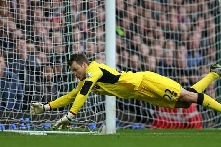 Kiper Liverpool, Simon Mignolet, berupaya mengantisipasi bola pada laga Premier League kontra West Ham United di Upton Park, 2 Januari 2016.