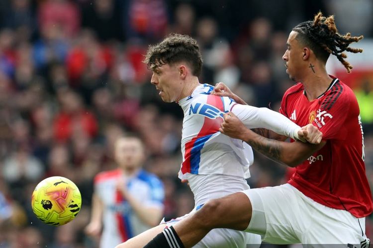 Jorgen Strand Larsen dibayangi Leny Yoro dalam pertandingan sepak bola Liga Inggris antara Manchester United vs Crystal Palace di Old Trafford di Manchester, barat laut Inggris, pada 1 Maret 2026. (Foto oleh Darren Staples / AFP)