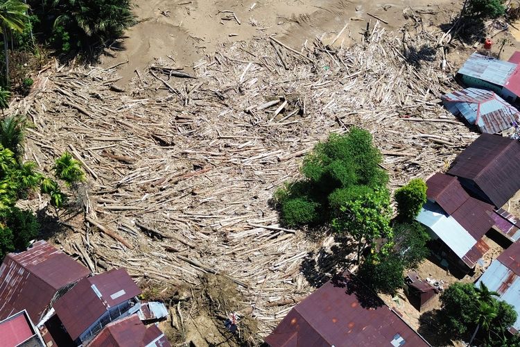 Foto udara tumpukan gelondongan kayu di permukiman di Tabiang Bandang Gadang, Nanggalo, Padang, Sumatera Barat, Selasa (9/12/2025). Gelondongan kayu yang terbawa banjir bandang sejak dua pekan lalu masih tersangkut di wilayah itu.  