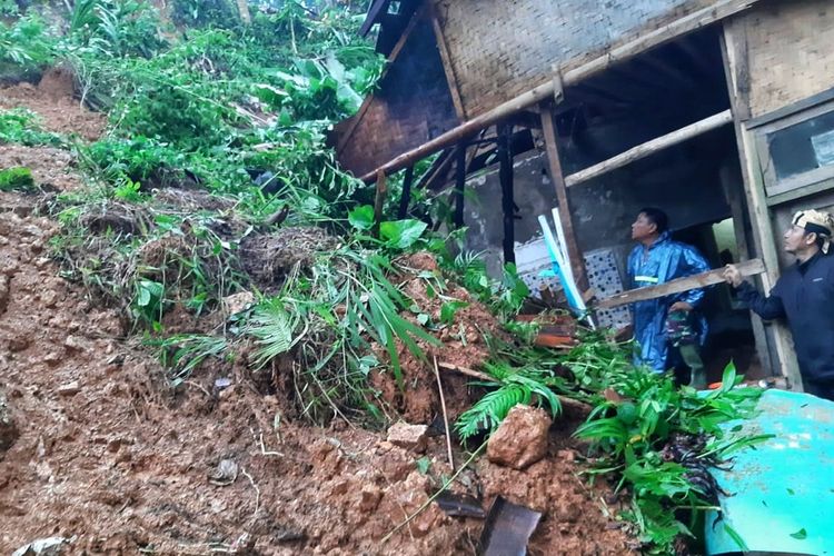 Dua petugas  mengecek lokasi bencana tanah longsor di Kampung Cikiray, Desa Sirnaresmi, Cisolok, Sukabumi, Jawa Barat, Minggu (16/2/2020).