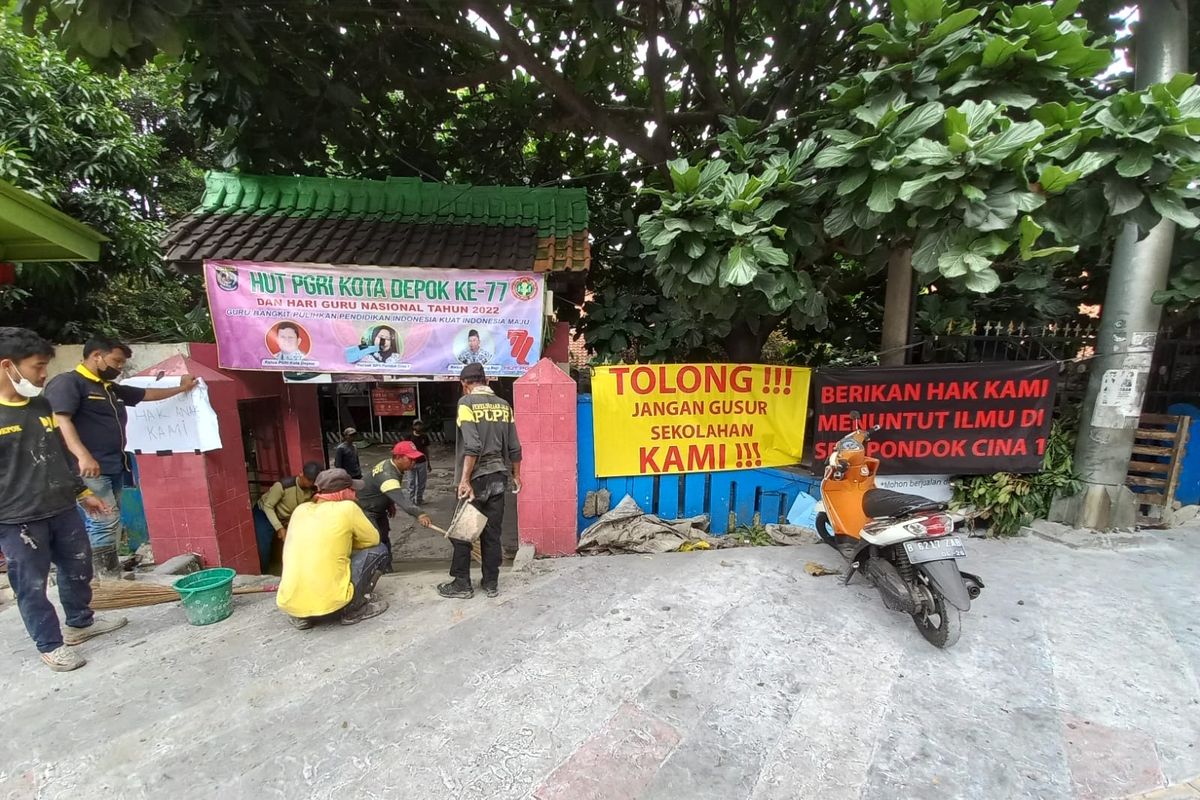 Dikeluhkan orangtua siswa lantaran revitalisasi trotoar Margonda lebih tinggi daripada permukaan sekolah, petugas Dinas PUPR Kota Depok tengah membuat akses jalan menuju SDN Pondok Cina 1, Beji, Depok pada Rabu (9/11/2022).