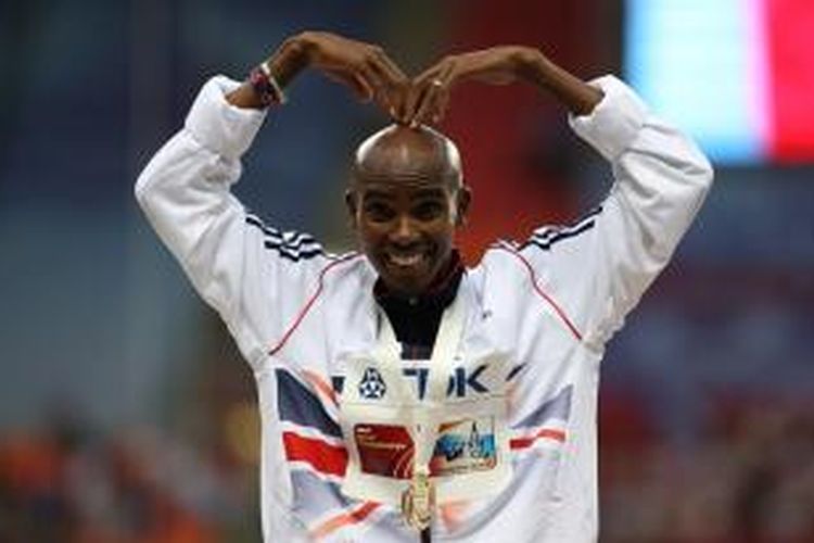 Pelari Inggris Mo Farah dengan gaya khasnya di atas podium usai pengalungan medali emas setelah dia memenangkan final nomor 10.000 meter dalam kejuaraan dunia atletik 2013 di Moskwa, Rusia.