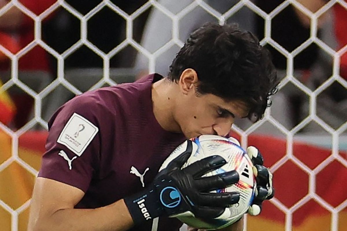 Kiper Maroko Yassine Bounou mencium bola saat adu penalti selama pertandingan sepak bola babak 16 besar Piala Dunia 2022 Qatar antara Maroko vs Spanyol di Education City Stadium di Al-Rayyan, barat Doha pada Selasa 6 Desember 2022.
